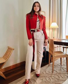 a woman in red jacket and white pants