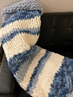 a blue and white blanket sitting on top of a couch