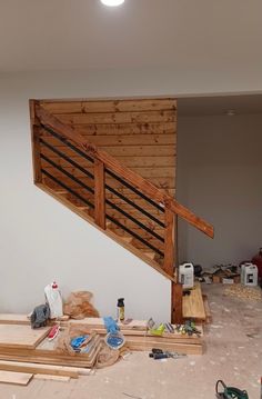 an unfinished stair case with wood slats and construction tools on the floor next to it