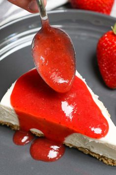 someone is dipping some kind of cheesecake with strawberries