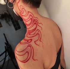 the back of a woman's neck with red swirls on her body and behind it is a white wall