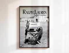 a black and white photo of a movie poster hanging on a wall next to a chair