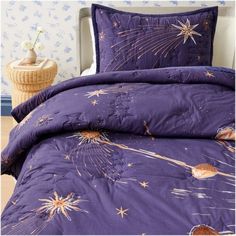 a purple comforter set with fireworks and stars on it