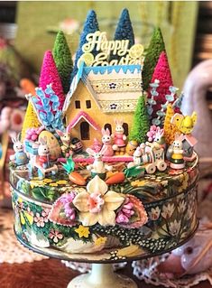 an elaborately decorated cake with figurines on it's sides and trees in the background