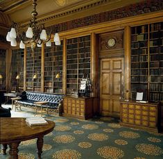 an old library with many bookshelves and leather couches in front of a chandelier