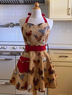 a mannequin wearing a dress with chickens on it in front of an oven