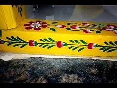 a yellow bench with flowers painted on it