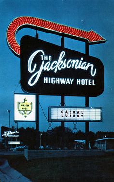 the sign for the jackson highway hotel is lit up in red and white letters that read, the jacksonian highway hotel