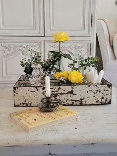 yellow flowers in an old wooden box on a table