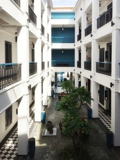 an indoor courtyard with several balconies and potted plants