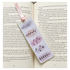 an open book with some writing on it and a pink ribbon attached to the bookmark