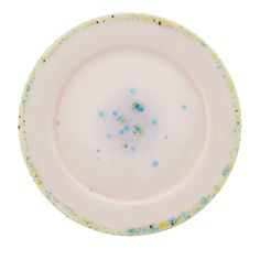 an empty white plate with blue and yellow speckles on the rim against a white background