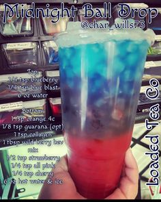 a hand holding up a cup filled with blue and red liquid