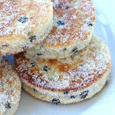 blueberry pancakes stacked on top of each other in a white plate with powdered sugar