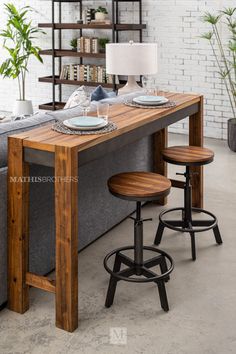 a kitchen table with two stools next to it and a couch in the background