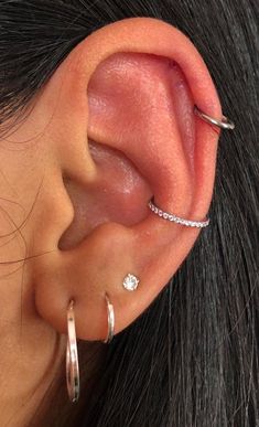 a close up of a person's ear with two different piercings on it