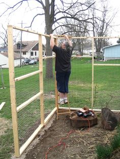 a man standing on top of a pile of dirt next to a fence