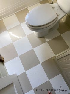 a white toilet sitting on top of a checkered floor