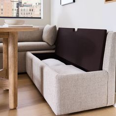 a couch that is sitting in the middle of a room next to a table with a bowl on it