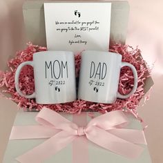 two coffee mugs sitting in a gift box with pink bows and a note on it