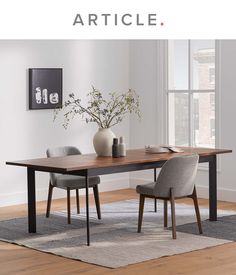 a dining table with two chairs and a vase on the table in front of it