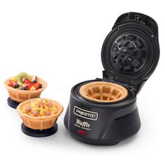 the waffle maker has two bowls of fruit in it and is ready to be eaten