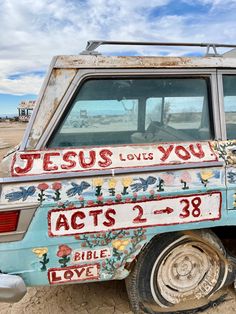 an old car with the word jesus loves you painted on it