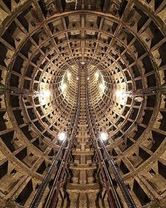 looking up at the ceiling of a train station with multiple tracks in it and lights on