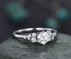 a three stone diamond ring on top of a rock