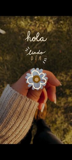 a person holding a flower in their hand with the words hola linda on it