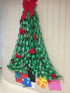 a christmas tree made out of toilet paper with ribbons and tags attached to the top