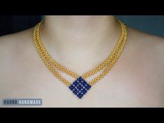 a woman wearing a gold necklace with blue beads