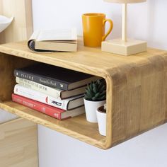 a wooden shelf with books and a cup on it