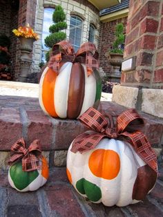 three pumpkins with bows sitting on the steps