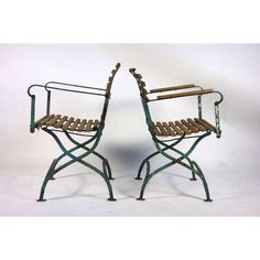 two chairs made out of metal and wood are sitting side by side on a white background