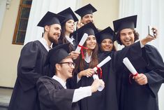 a group of people in graduation gowns posing for a photo