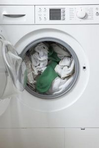 an open washing machine with clothes in it