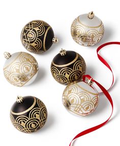 four ornaments with red ribbon on white background, including one black and gold ornament