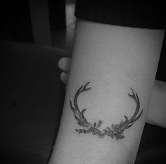 a black and white photo of a deer's antlers tattoo on the arm