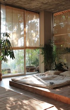 a bed sitting in the middle of a room with lots of windows