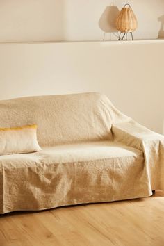 a couch covered with a beige linen cover