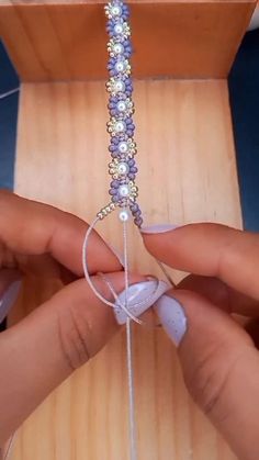 someone is making something with beads and string