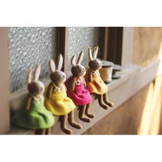 four little bunnies are hanging on the window sill