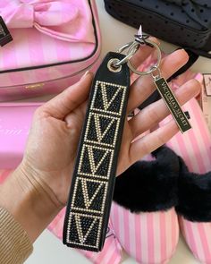 a hand holding a keychain that has an arrow design on it and is next to other items