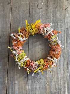 a wreath made out of yarn sitting on top of a wooden floor