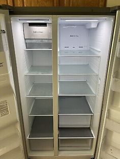 two open refrigerators sitting side by side in a kitchen