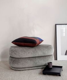 a stack of pillows sitting on top of each other in front of a white wall