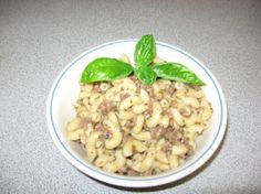 a white bowl filled with macaroni and cheese on top of a gray counter