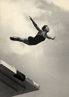 an old photo of a man diving into the water