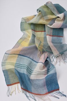 a multicolored plaid scarf laying on top of a white surface